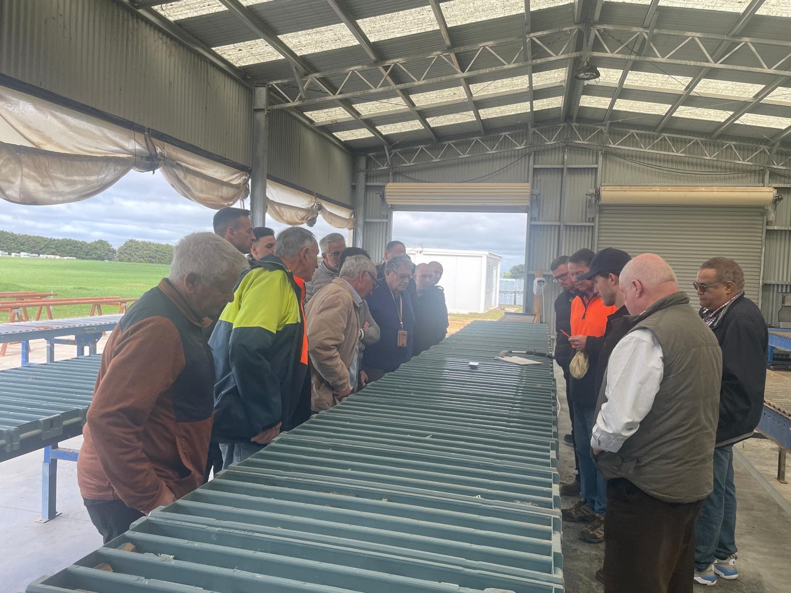 A group gathered around drill core trays for a discussion in a core shed.
